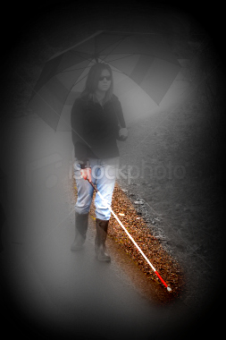 The original photo of the woman with the cane is modified so that the edges of the photo are dark, it is in black and white and is severely blurry except for her cane, which is in enhanced color and is very clear